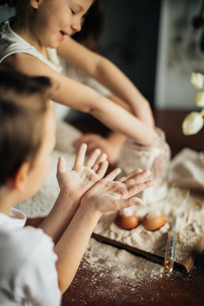 Joyful children baking and playing with flour in the kitchen.