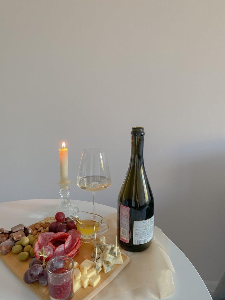 A sophisticated charcuterie board with wine and candlelight, perfect for dinner ambiance.