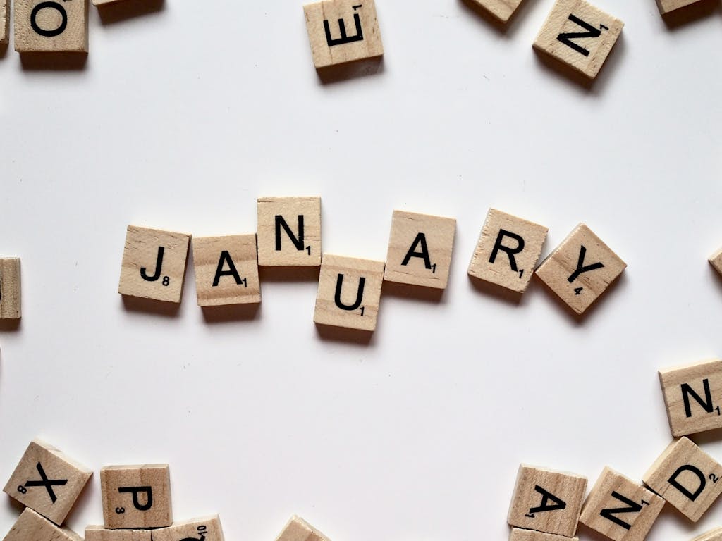 Close-up of Scrabble tiles spelling 'January' on a white surface, perfect for winter or new year themes.