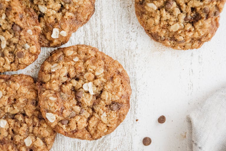 Close-up of homemade oatmeal chocolate chip cookies on a rustic wooden table. Perfect for food blogs.