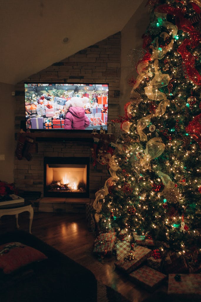 Warm living room with a decorated Christmas tree and a cozy fireplace, perfect holiday ambiance.